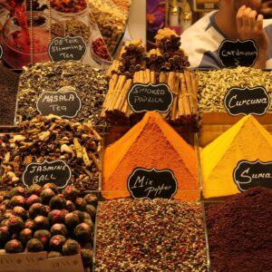 Colorful assortment of traditional Turkish spices and teas in a bustling market setting.